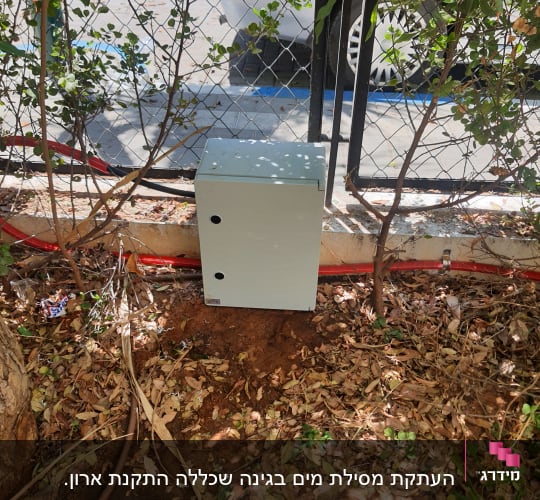 צינור חום על הקרקע ליד קופסה אפורה